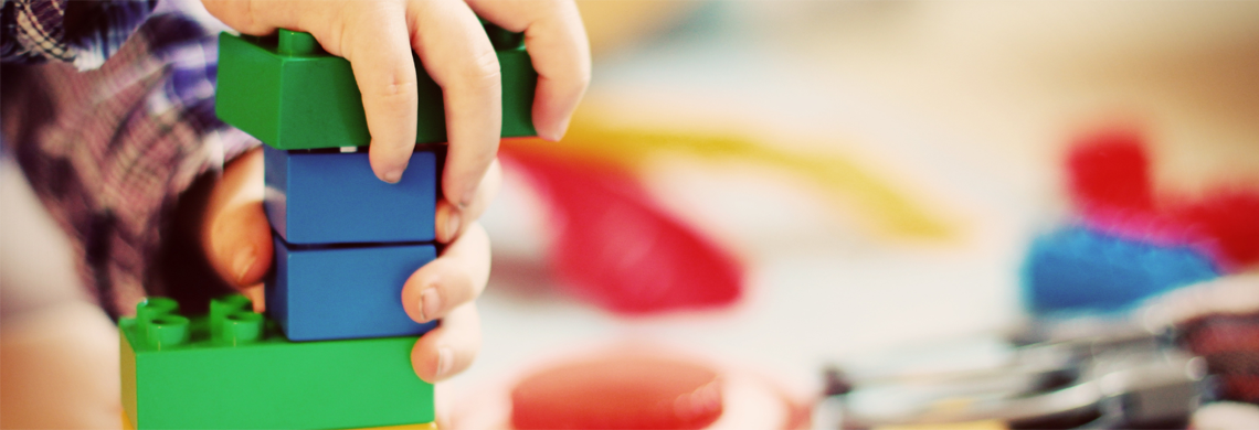Kinderhände bauen mit Lego